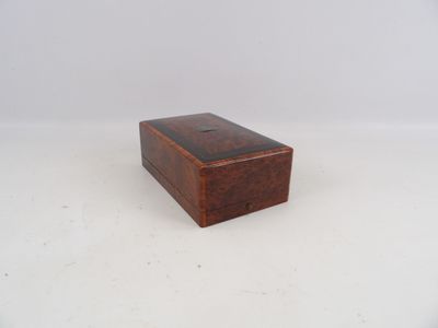 une petite boîte en bois posée sur une surface blanche