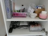 a white shelf with a lot of makeup and other items on it