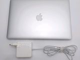 an apple laptop computer sitting on top of a table next to a charger