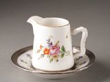 a small cup and saucer on a saucer on a table