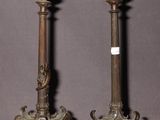 une paire de bougeoirs anciens en bronze sur socles, sur fond gris