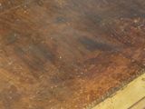 a close up of a wooden table with a piece of wood on it