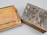 two wooden boxes with carvings on them sitting next to each other