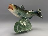 sculpture représentant un poisson perché sur un rocher, posée sur une surface grise