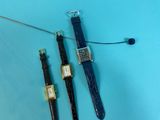 two watches are sitting next to each other on a blue surface