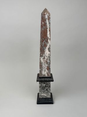marble obelisk on a marble base with a black base