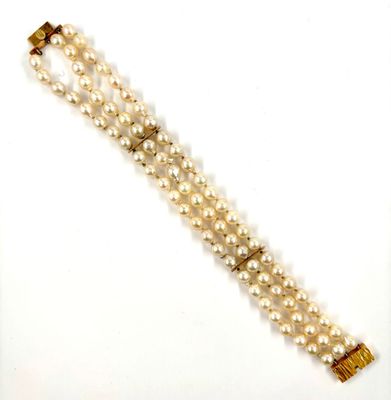 a close up of a bracelet with pearls on a white background