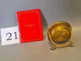 a gold clock sitting next to a red book