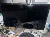 a flat screen tv sitting on a desk with a keyboard and mouse