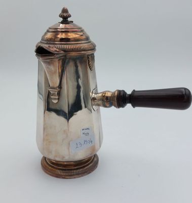une cafetière ancienne en argent avec une poignée en bois sur fond blanc