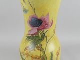 a yellow vase with a flower painted on it