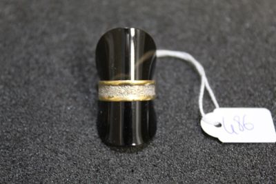 a ring with a gold band on a black surface