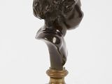 an antique bronze bust of a young boy on a marble base