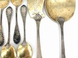 a lot of silver spoons and spoons on a white surface