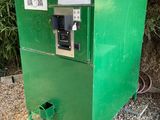 a green vending machine sitting on the side of the road