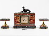 une horloge surmontée d'un chien, à côté de deux tabourets