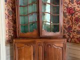 un meuble en bois avec une porte en verre dans une pièce