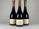 trois bouteilles de champagne posées côte à côte sur une table