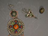 three pieces of jewelry are displayed on a gray surface