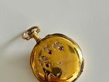 an image of a gold pocket watch on a white surface