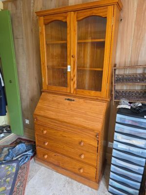 un meuble en bois avec une porte en verre dans une pièce