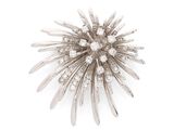 une image représentant une broche en diamant et en argent sur fond blanc