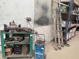 une étagère verte sur laquelle sont posés des outils, à côté d'une échelle