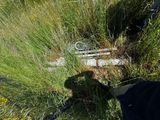 un sac noir posé dans l'herbe près d'une clôture