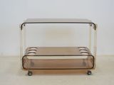 an image of a glass and brass coffee table on wheels
