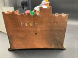 a small wooden toy castle with a man on top of it