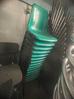 a stack of green chairs in a room with white tile walls