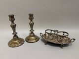 deux bougeoirs en argent et un plateau posés sur une table