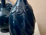 deux vases bleus posés l'un à côté de l'autre sur une table