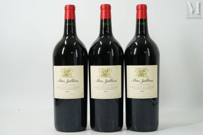 trois bouteilles de vin rouge posées sur une table blanche