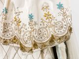 a white dress with blue and gold embroiderys on it