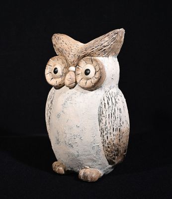 une image représentant une figurine de hibou en céramique sur fond noir