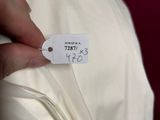 a person holding a white dress with a price tag on it