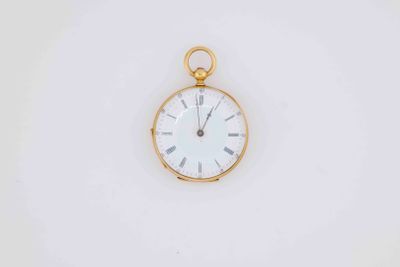 a close up of a pocket watch on a white surface