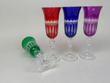 four different colored wine glasses sitting next to each other on a white surface