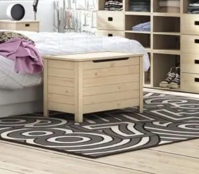 une chambre avec un lit, des commodes et un tapis au sol