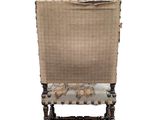 the back of a chair with a woven upholstered seat and wooden legs