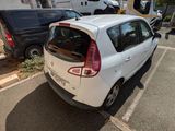 une voiture blanche garée dans un parking à côté d'un bâtiment