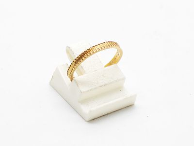 a close up of a gold ring on a white marble block