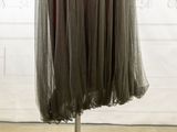 a dress on a mannequin stand in front of a wall