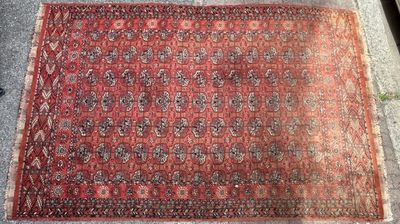 un tapis posé par terre au milieu d'un trottoir, avec un chat assis dessus