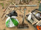 un tas d'outils et un sac de terre posés par terre