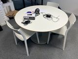 a white table with four chairs and a laptop on it