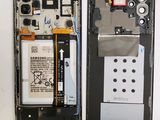 the back of a cell phone with a broken battery and a broken battery
