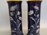 deux vases avec des fleurs peintes dessus, posés sur une table