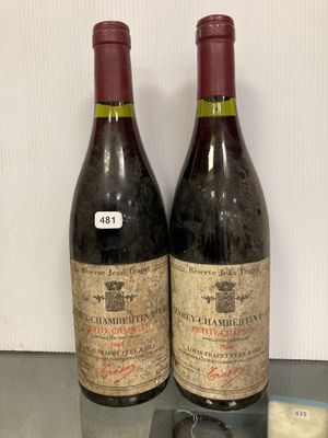 deux bouteilles de vin posées sur une table en verre, à côté d'une bouteille de vin